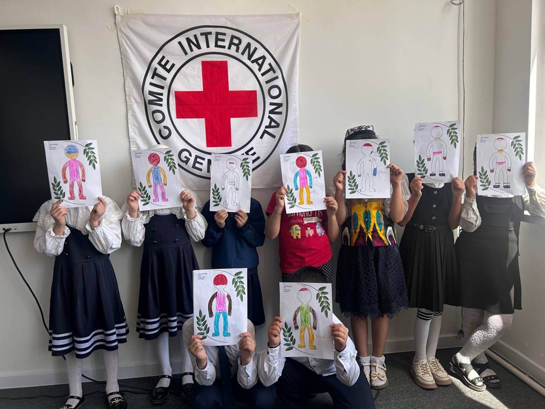 Children during an ICRC focused psychosocial support session hold up “body-mapping of emotions” drawings - a tool that helps children connect emotions with bodily sensations and communicate how they are feeling. Tashkent, Uzbekistan.