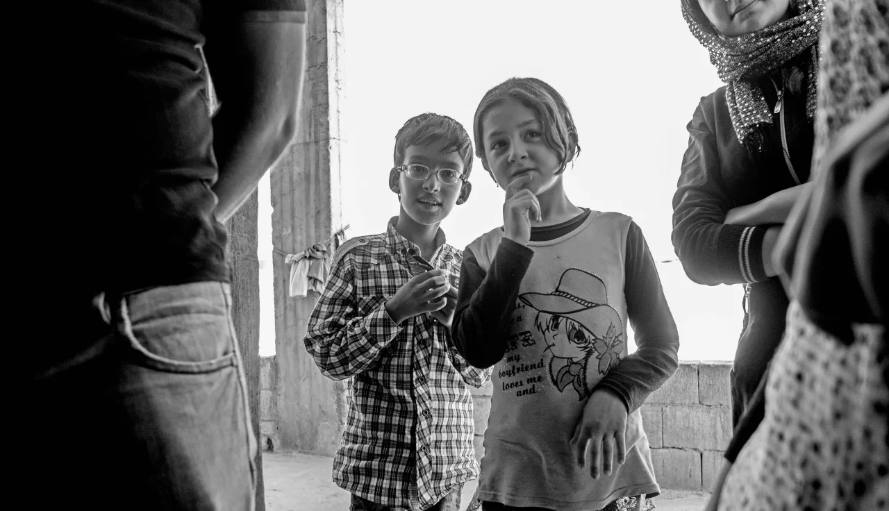 Two children looking on in a gathering in Arsal, Lebanon.