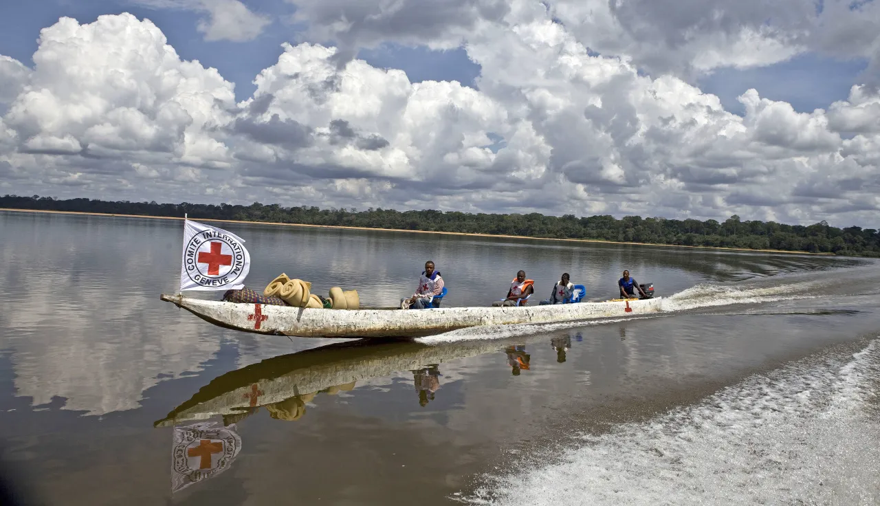 An ICRC team travels by pirogue to Balombe to distribute farming equipment and fishing supplies in the Democratic Republic of the Congo.