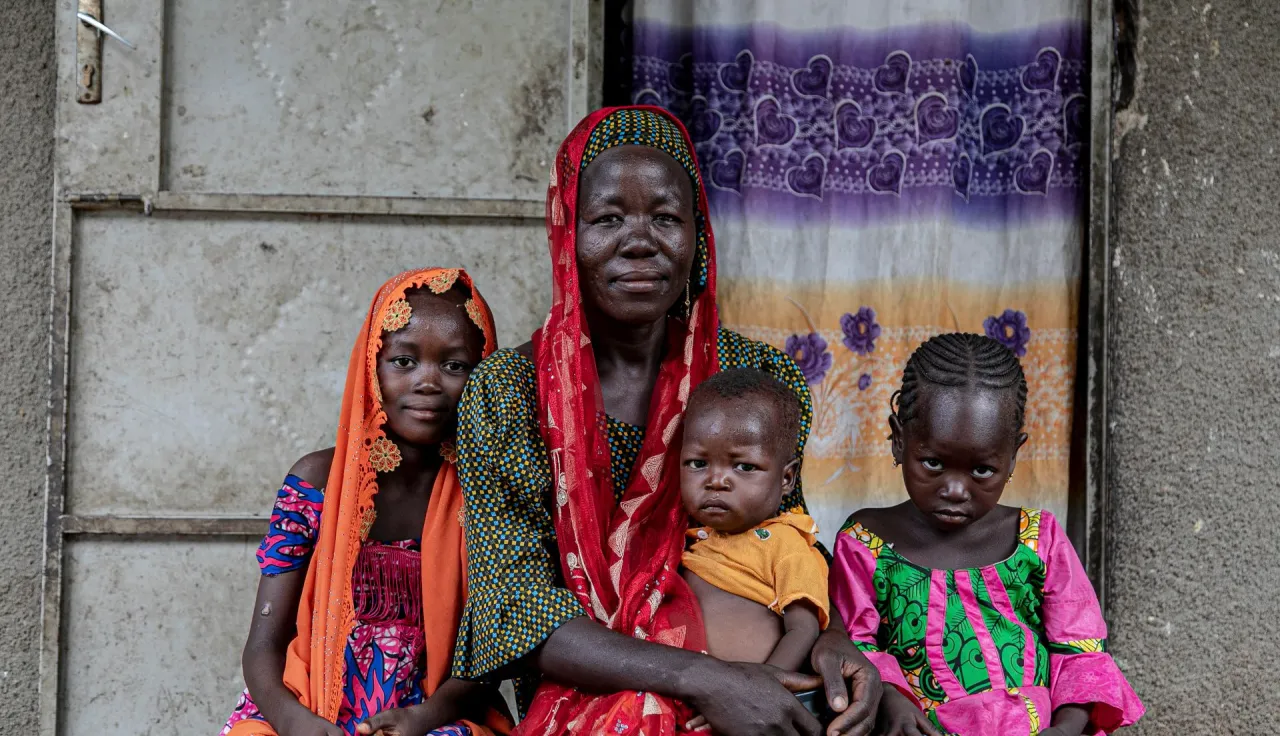 Portrait of a woman and her children in front of their house in Maroua.