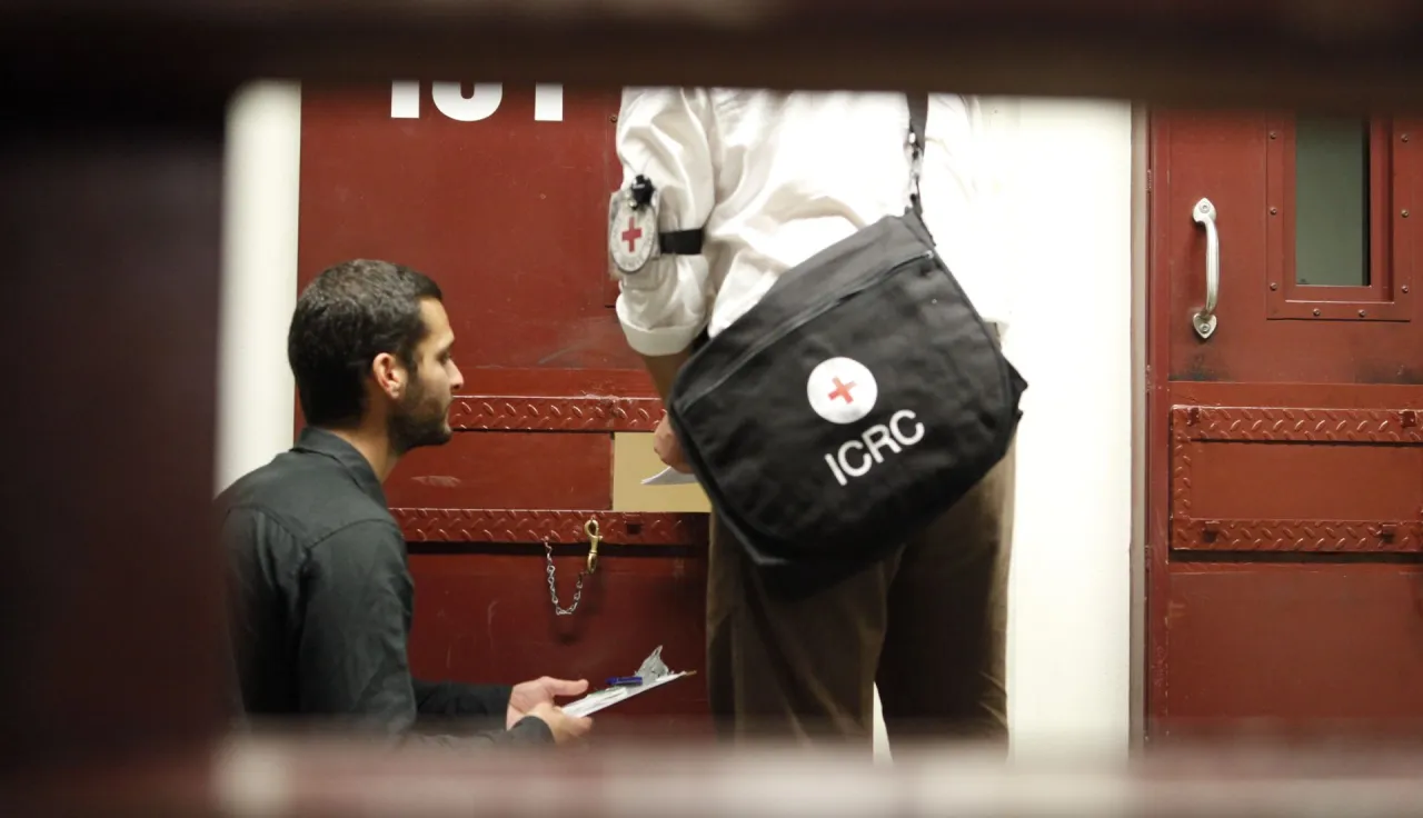 ICRC delegates deliver a Red Cross message to a detainee.