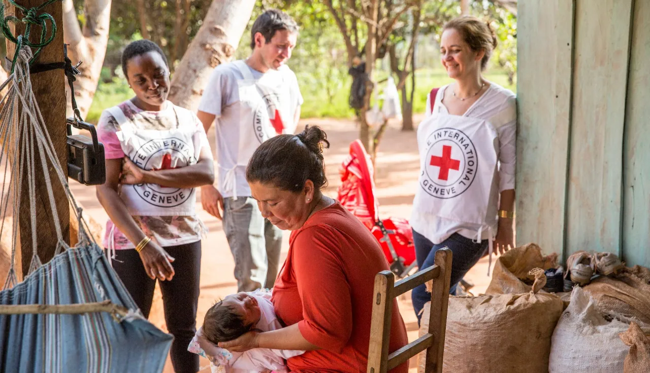 ICRC employees with a woman and a child