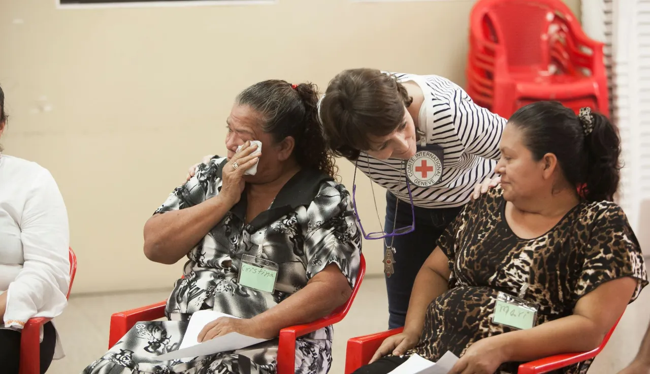 During an accompaniment meeting, an ICRC employee speaks with the families of missing migrants in San Salvador.
