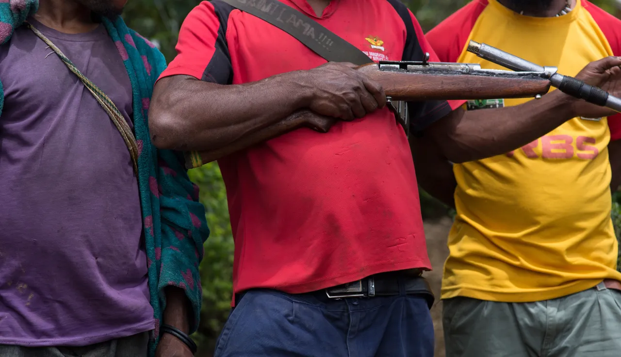 Tribal fighters stand in civilian clothes with their homemade gun in Papua New Guinea.