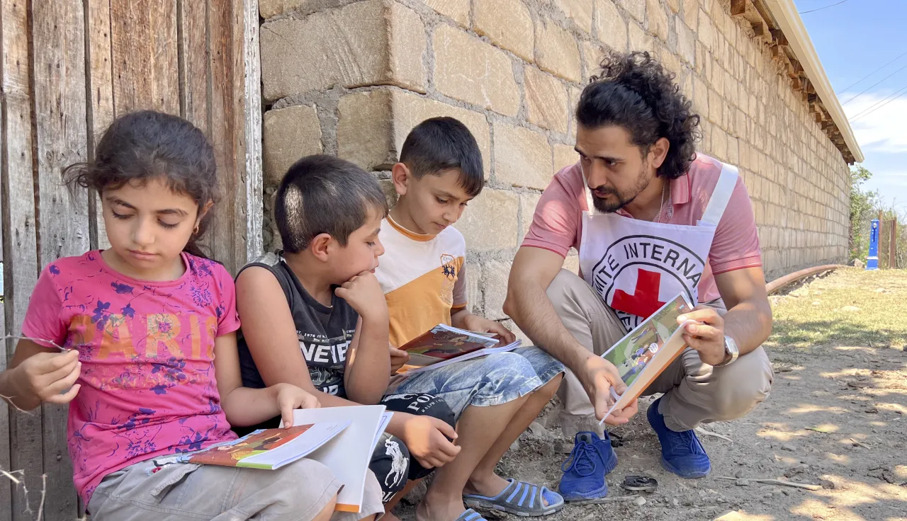 The ICRC distributes flyers to children to inform them on the danger of landmines in Tovuz, Azerbaijan.