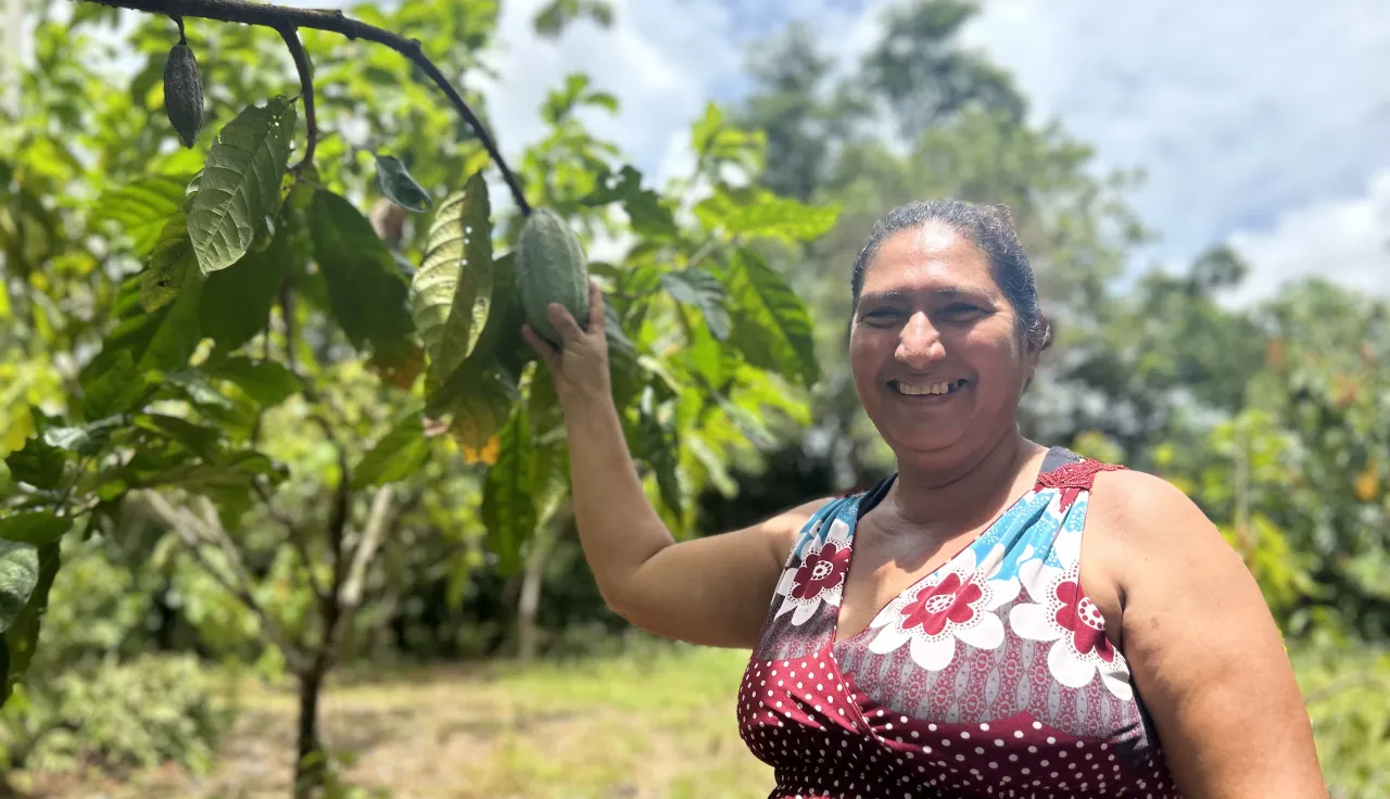 Mujer muestra su plantación de cacao.