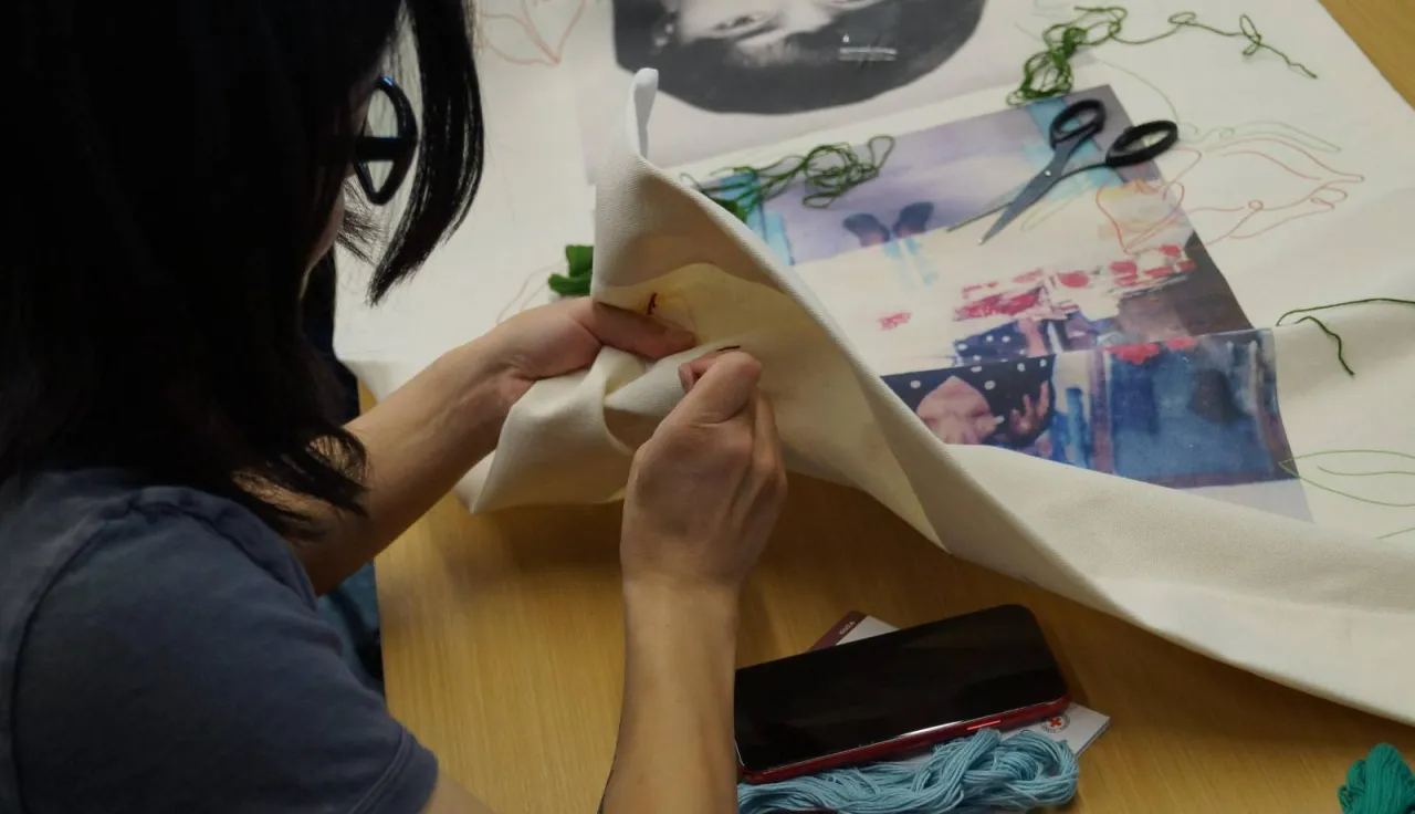 una persona bordando las telas para la exhibición 