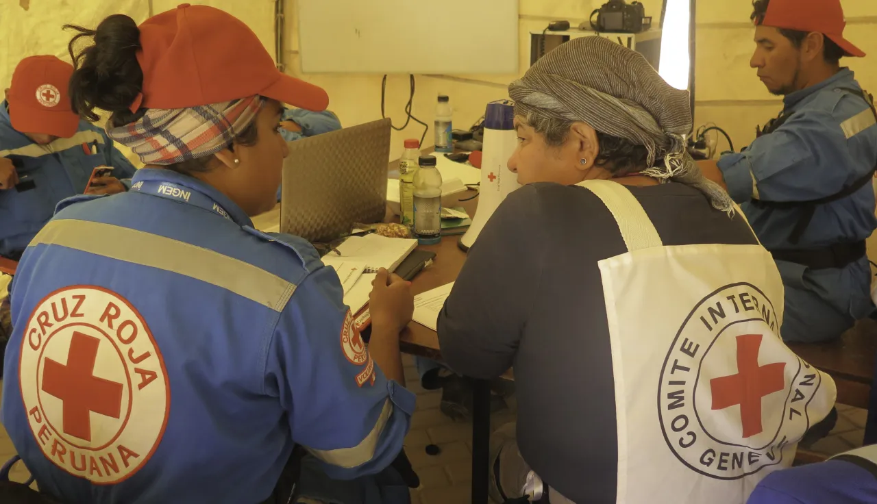 The ICRC Prevention and Influence work in Peru | Photo: Nicol Flores ICRC and Red Cross delegates sitting with their backs to the camera wearing the emblem on their clothing