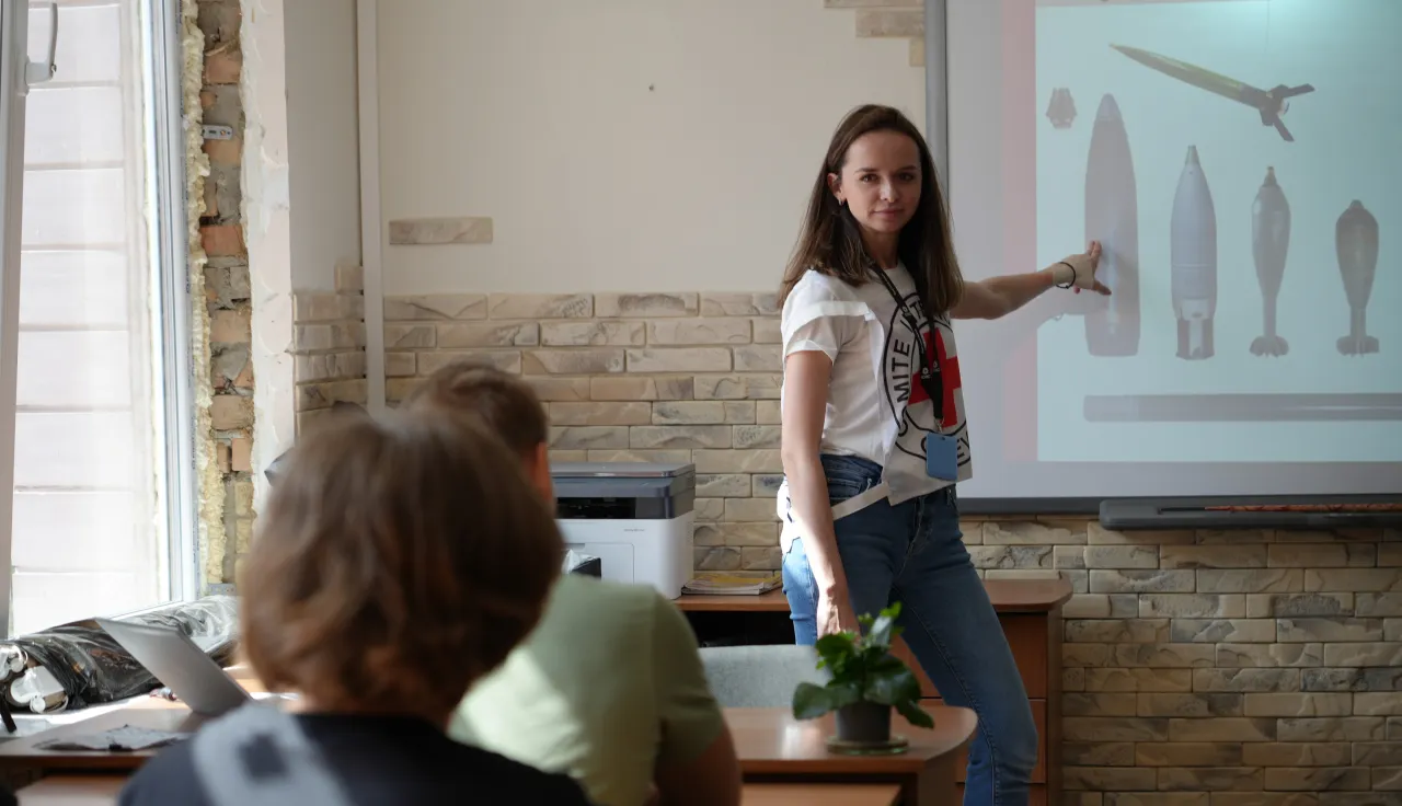 An ICRC field officer delivers safety lessons about the dangers of explosive ordnance at school. Anna Bilous/ICRC