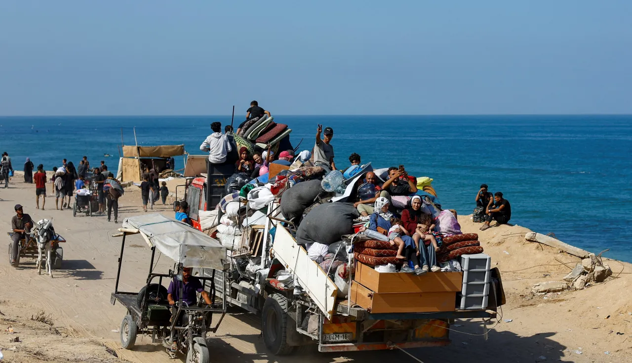 Gaza-City-September-2025-CREDIT-REUTERS-CONNECT_GAZA.JPG A crowded truck loaded with people and belongings drives along a coastal road, as others walk or travel on carts beside the sea.