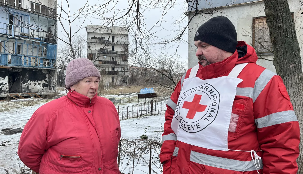 ICRC staff talks to Galina in in Krasnohorivka where ICRC distributed aid to the affected population.