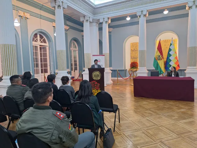 Ministro toma la palabra en un salón.