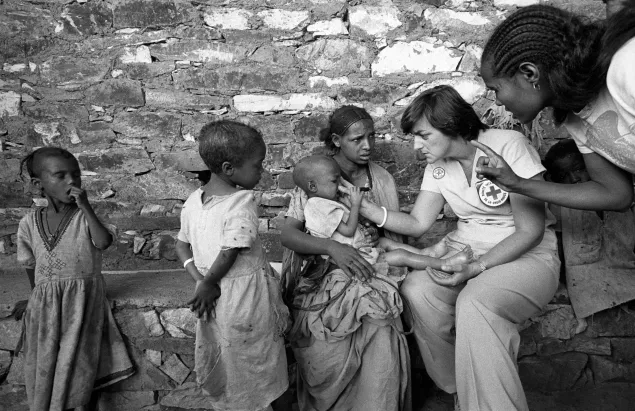 1985-03-28 Axum, Ethiopia,  New Zealand Red Cross nurse examining a baby girl. She is 3 years old and suffers from marasmus and kwashiorkor.