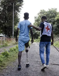 Tigray, Hospital de Shire. Un miembro del equipo de rehabilitación física del CICR ayuda a un paciente a practicar la marcha con su prótesis. Tigray, Hospital de Shire. Un miembro del equipo de rehabilitación física del CICR ayuda a un paciente a practicar la marcha con su prótesis.