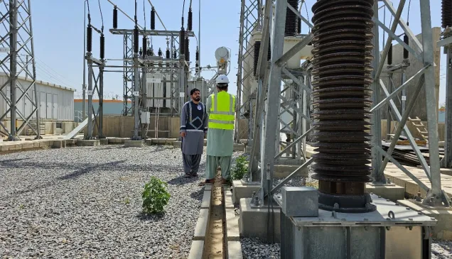 ICRC's Water and Habitat staff - Ahmad Zia Abdali (on the left) - assessing the power line to the Mirwais Regional Hospital with an official from Afghanistan’s electricity company.