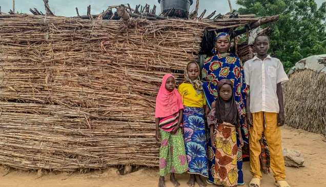 Fana Biri posing in front of her home with her children