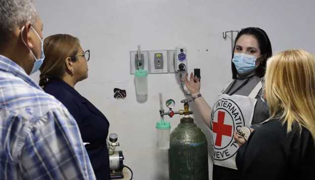 Una trabajadora del CICR le explica al personal de salud del hospital de El Callao, cómo hacer el mantenimiento al sistema de gases medicinales