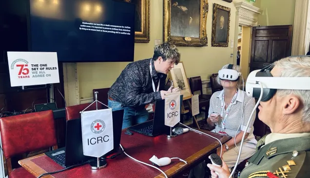 Two people wearing virtual reality headsets sat around a table