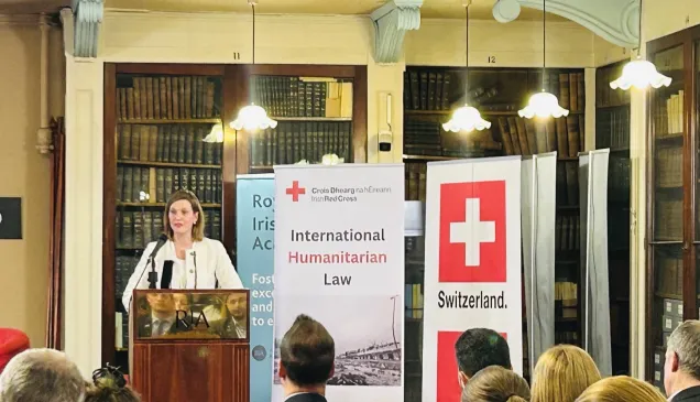 An ICRC colleague speaking behind a lectern 