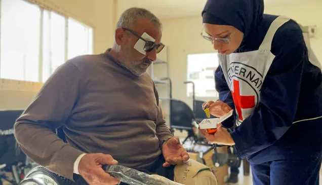 Rajaa Ewaidah practices the use of his new wheelchair with ICRC physiotherapist Saeda Albarawi at Al Amal Hospital in Khan Younis. Rajaa lost his legs due to a severe injury from an airstrike. Ahmed Al Waheidi / ICRC 