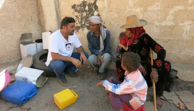 Wusab Assafil district, Yemen: An ICRC staff member answers beneficiaries' questions about the ICRC and the ongoing distribution for internally displaced persons.