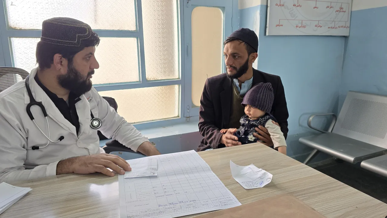 A doctor examining little Bushra at a Basic Healthcare Clinic in Kandahar.