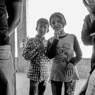 Two children looking on in a gathering in Arsal, Lebanon.