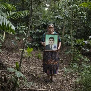 Fotografía de la hija de Paula Martín, sujetando un retrato de su padre Margarito. 