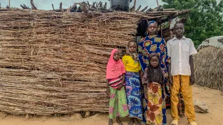 Fana Biri posing in front of her home with her children