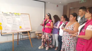 Women in a room looking at a whiteboard