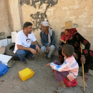 Wusab Assafil district, Yemen: An ICRC staff member answers beneficiaries' questions about the ICRC and the ongoing distribution for internally displaced persons.