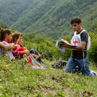 ICRC staff teaching children in field