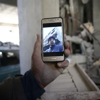Abu Mohammad Alaya, 50, holds a mobile phone with a picture of his son Mohammad, who was killed in Douma on March 2, 2018.