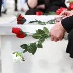 Red roses being placed at a memorial