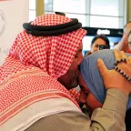 A Syrian refugee takes his missing daughter in his arms and kisses her on the forehead