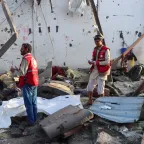 NR Yemen strikes Two Red Crescent workers stand amidst the wreckage caused by an explosion