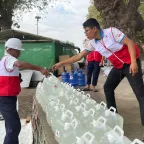 ICRC workers providing clean water containers in Myanmar