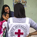 Norte de Santander, Catatumbo region, San Calixto. The walls of Johana's store have been impacted by the conflict. She hugs her daughter and talks to an ICRC employee. Andres Cortes/ICRC A mother hugs her daughter as she talks to an ICRC field staff in Norte de Santander, Catatumbo region, San Calixto.