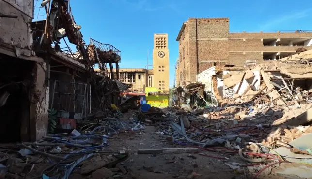 Critical infrastructure in Sudan destroyed, with a clocktower still standing in the background