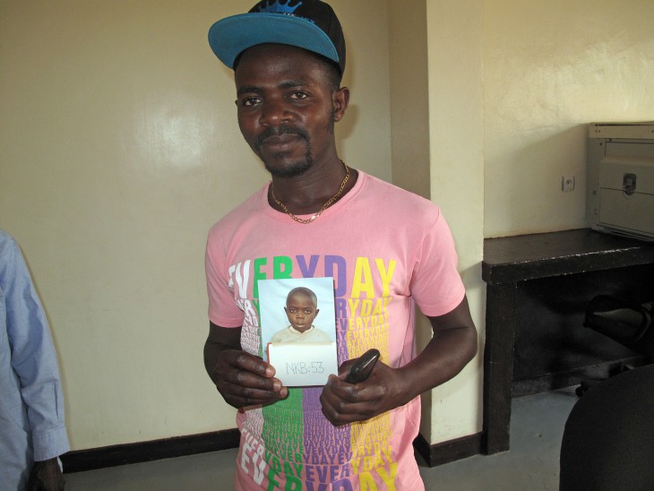 Raymond displays a photo of himself taken in 1994, shortly after the Rwandan genocide separated him from his family.
