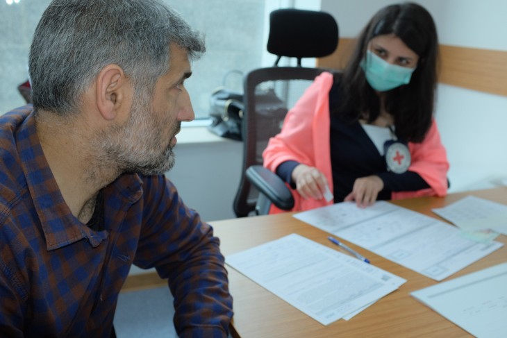 A staff member completes the documentation on a person whose relative has been missing since the Nagorny Karabakh conflict.