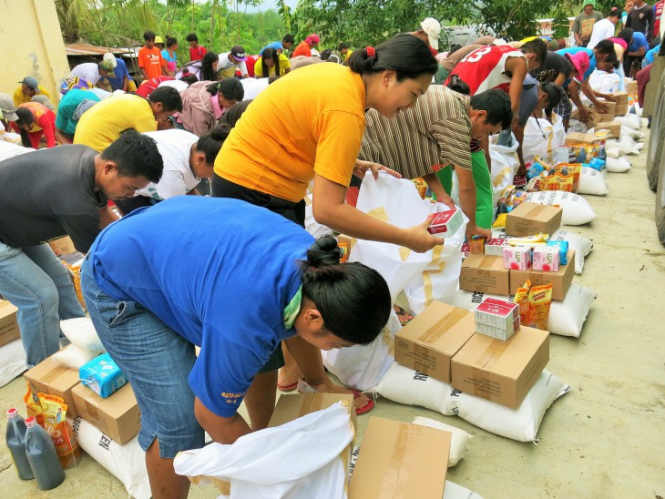 People collect food and essential supplies at a joint ICRC/Philippine Red Cross distribution