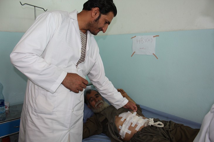 Surgical team head Dr Mirwais Mangal Khail inspects a patient recovering after an operation for a perforated ulcer, carried out using suturing techniques learned from the ICRC team.